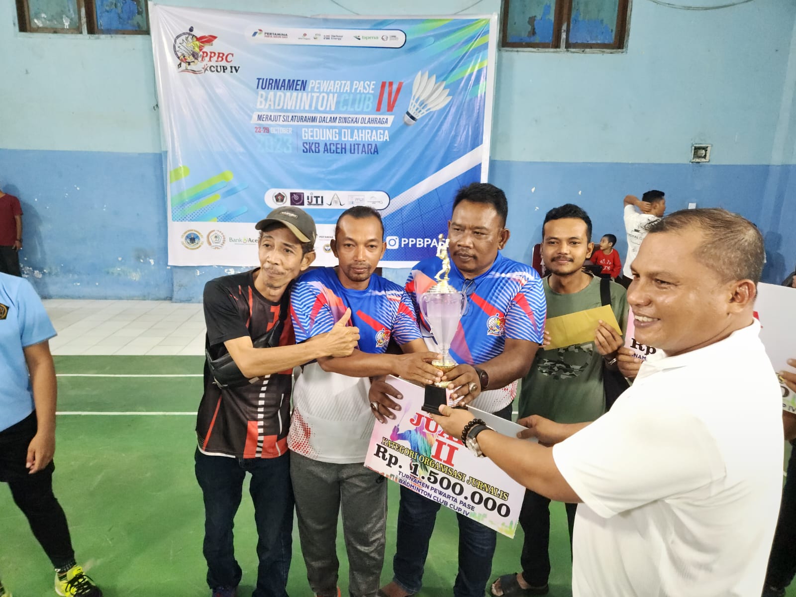 Iptu Zahabi menyerahkan piala kepada pemenang turnamen bulu tangkis Pewarta Pase Badminton Club (PPBC) Cup IV di gedung BKPSDM Aceh Utara di Lhokseumawe